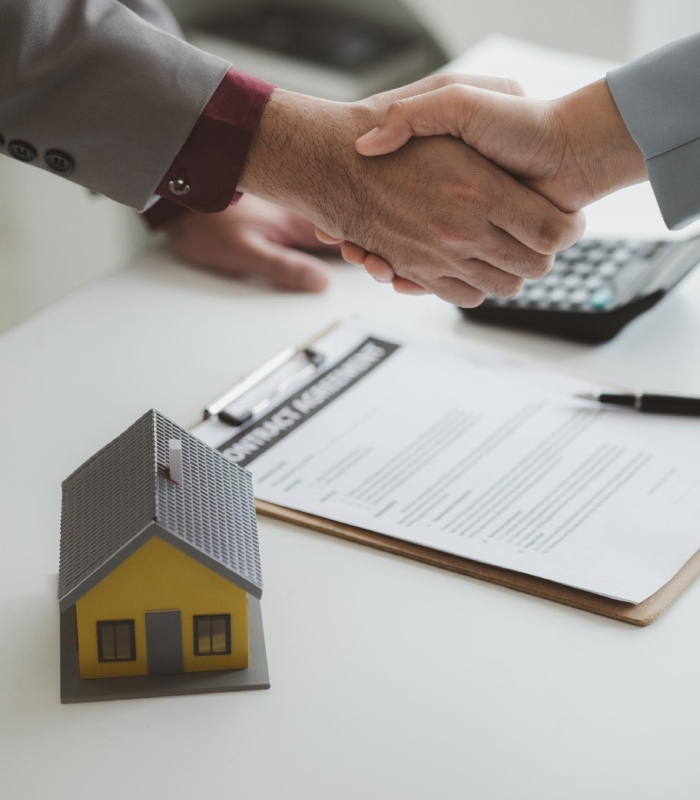 Poignée de main entre un courtier et un client après la signature d’un prêt immobilier