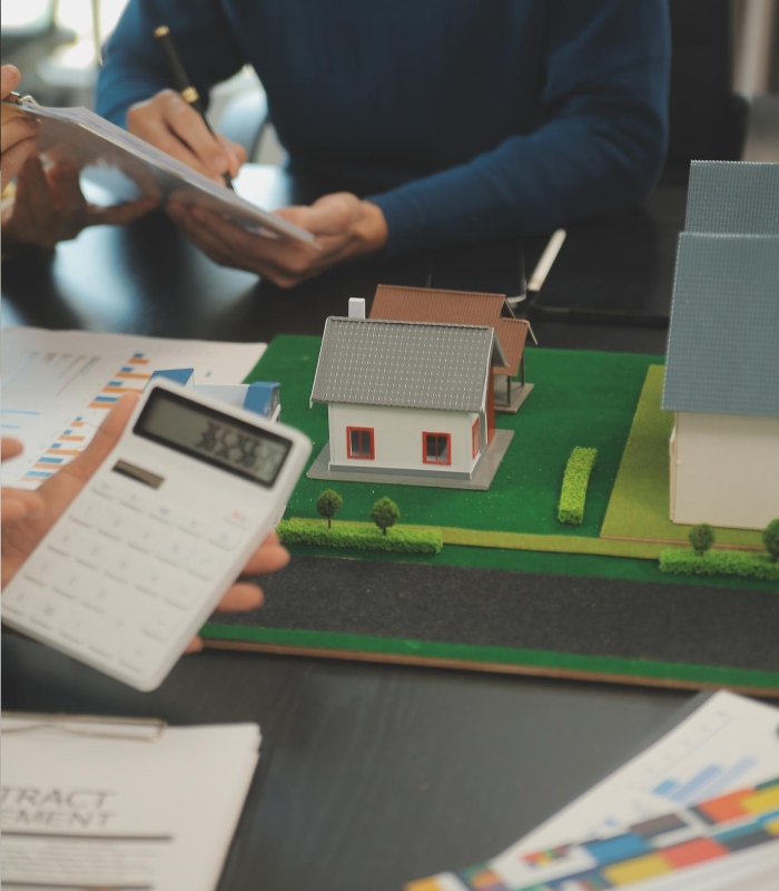 Simulation de crédit immobilier avec calculs et maquette de maison sur bureau